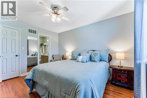 Spacious bedroom featuring wood-finish flooring, a ceiling fan with integrated lighting, and a neutral wall color - 4057 Donnic Drive, Burlington, ON - Indoor Photo Showing Bedroom