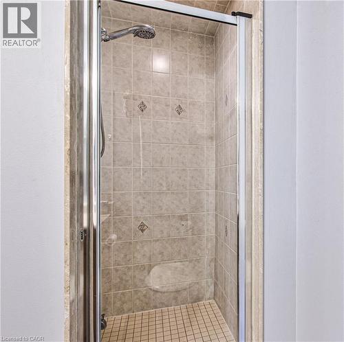 Tiled shower enclosure with a clear glass door, featuring an integrated showerhead and a built-in bench - 4057 Donnic Drive, Burlington, ON - Indoor Photo Showing Bathroom