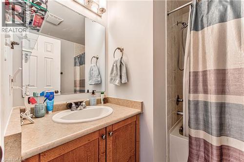 Bathroom vanity featuring an integrated sink, broad countertop, and wood-finish cabinetry - 4057 Donnic Drive, Burlington, ON - Indoor Photo Showing Bathroom