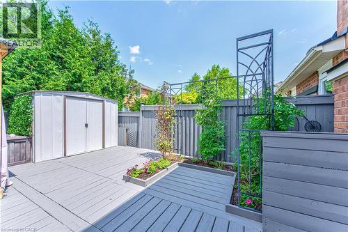 Expansive grey composite decking featuring a metal storage shed and integrated raised garden beds with trellises - 4057 Donnic Drive, Burlington, ON - Outdoor With Deck Patio Veranda With Exterior