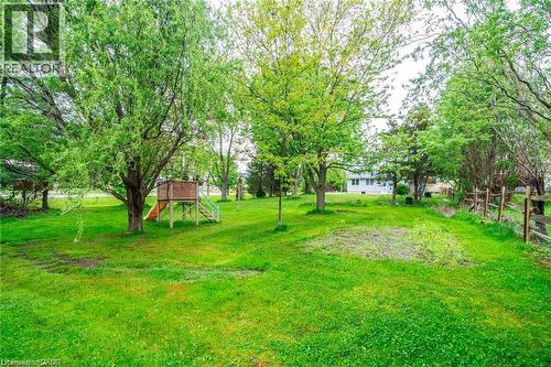 Expansive green lawn with mature trees and a rustic wood fence - 2583 Binbrook Road, Binbrook, ON - Outdoor