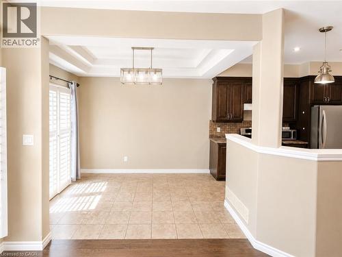 Open-concept space featuring a coffered ceiling, tile flooring, and a modern rectangular chandelier - Upper-313 Featherstone Crescent, Kitchener, ON - Indoor Photo Showing Kitchen