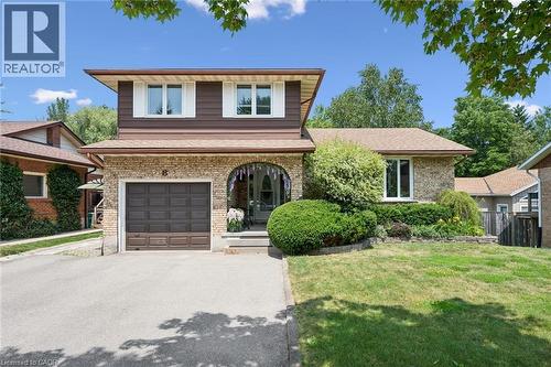 Brown and brick exterior featuring an arched entryway, integrated garage, and a paved driveway - 8 Perin Place, Kitchener, ON - Outdoor