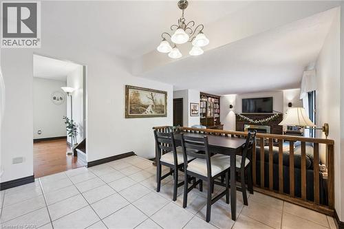 Tiled flooring in an open-concept area featuring a dining space with a dark wood table and chairs - 8 Perin Place, Kitchener, ON - Indoor
