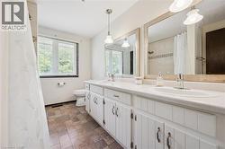 Double vanity with integrated sinks, white cabinetry, and brushed nickel hardware - 