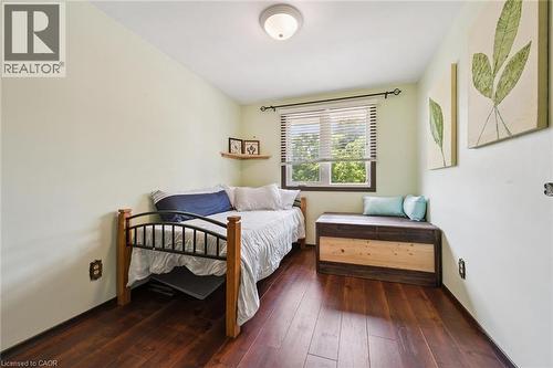 Bedroom featuring rich wood-finish flooring and a single window with blinds - 8 Perin Place, Kitchener, ON - Indoor Photo Showing Bedroom
