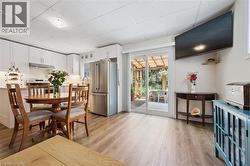 Bright kitchen with white cabinetry, stainless steel appliances, and wood-finish flooring - 