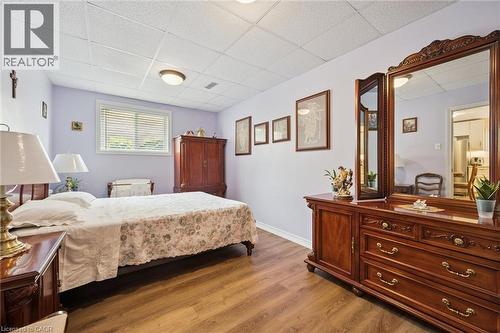 Bedroom featuring laminate wood-finish flooring, a window with blinds, and a drop ceiling with recessed lighting - 8 Perin Place, Kitchener, ON - Indoor Photo Showing Bedroom