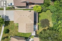 Aerial perspective showcasing the property's roofline, extensive rear decking, and a spacious green area with mature trees - 
