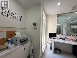 Bright reception area featuring a large window, built-in desk, and overhead recessed lighting - 