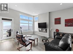 Inviting living room with expansive windows framing picturesque lake and valley views. - 