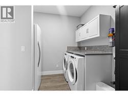 Convenient main floor laundry room with additional storage space. - 