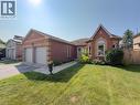 Brick exterior home featuring a two-car garage, bay window, front landscaping, paved walkway, and a manicured lawn - 60 Attwood Drive, Cambridge, ON  - Outdoor 