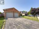 Brick exterior featuring a two-car garage with individual doors, a paved driveway, and a front yard with mature landscaping - 60 Attwood Drive, Cambridge, ON  - Outdoor 