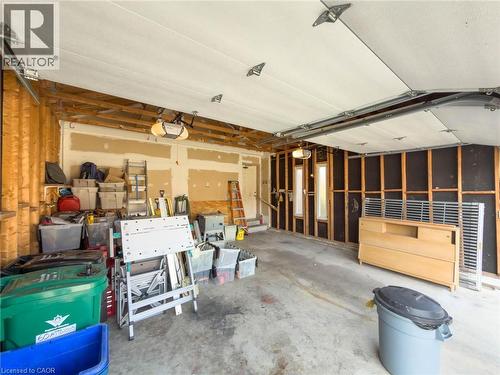 Spacious garage featuring concrete flooring, an automatic garage door opener, and visible framing ready for customization - 60 Attwood Drive, Cambridge, ON - Indoor Photo Showing Garage