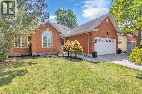 Brick exterior residence featuring a prominent arched window and a two-car garage - 65 Thistlemoor Drive, Caledonia, ON - Outdoor