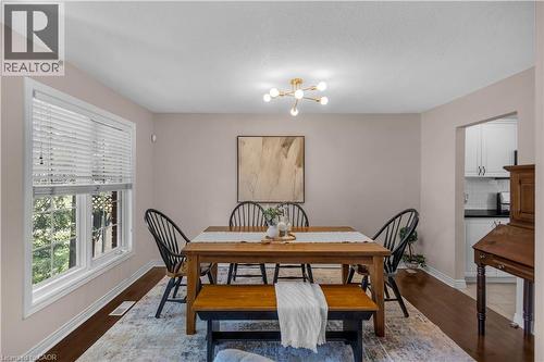 Dining area featuring wood-finish flooring and a contemporary sputnik chandelier - 65 Thistlemoor Drive, Caledonia, ON - Indoor Photo Showing Dining Room