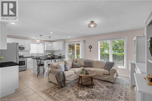 Open concept living area featuring a kitchen with white cabinetry, a dark countertop island, and stainless steel appliances - 65 Thistlemoor Drive, Caledonia, ON - Indoor