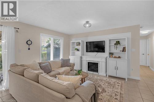 Living area featuring a built-in media center with shelving, white mantel, and electric fireplace - 65 Thistlemoor Drive, Caledonia, ON - Indoor Photo Showing Living Room With Fireplace