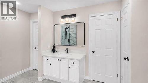 Bathroom vanity featuring a white countertop, under-mount sink, and matte black faucet - 65 Thistlemoor Drive, Caledonia, ON - Indoor Photo Showing Other Room
