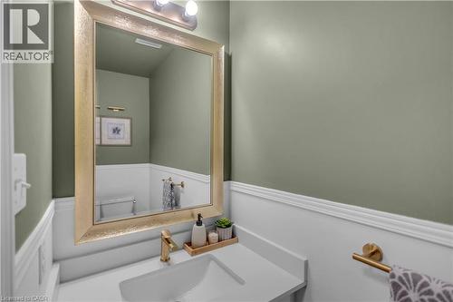 Bathroom vanity featuring a gold-framed mirror, contemporary single-handle faucet, and white countertop - 65 Thistlemoor Drive, Caledonia, ON - Indoor Photo Showing Bathroom