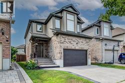 Modern two-story residence featuring a brick and siding exterior, an attached single-car garage, and a covered entry porch - 