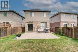 Rear exterior featuring a concrete patio, sliding glass door access, and a wood privacy fence - 