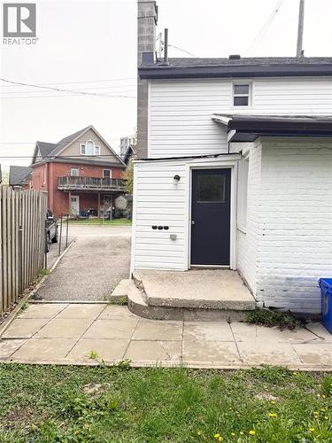 Rear exterior with white vinyl siding, a black door, and a concrete stoop - 190 Lancaster Street E, Kitchener, ON - Outdoor With Exterior