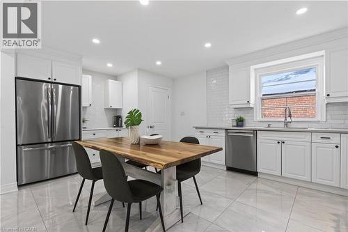 Bright kitchen featuring white shaker cabinetry, stainless steel appliances, white subway tile backsplash, and large format tile flooring - 258 Sanatorium Road, Hamilton, ON - Indoor Photo Showing Kitchen