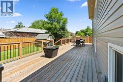 Spacious wooden deck featuring natural wood railing with black spindles - 