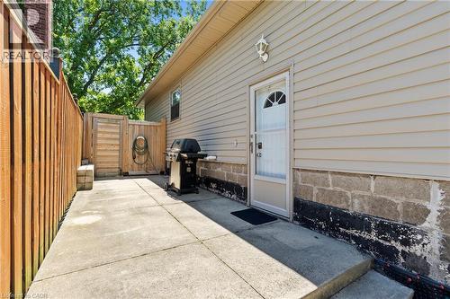 Concrete patio area with a privacy fence, wood gate, and exterior siding - 258 Sanatorium Road, Hamilton, ON - Outdoor With Exterior