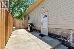 Concrete patio area with a privacy fence, wood gate, and exterior siding - 