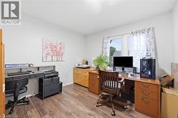 Bright interior space featuring wood-finish flooring and a white wall finish - 
