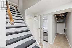 Staircase with contrasting black treads and white risers, featuring a natural wood handrail - 