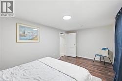 Room featuring wood-finish flooring, light grey walls, and a white interior door - 