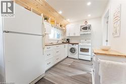 Kitchen featuring wood-finish flooring, white cabinetry, wood-look countertops, and recessed lighting - 