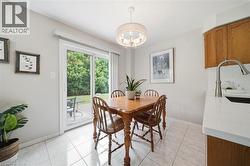 Dining area featuring a contemporary drum pendant light fixture, tile flooring, and a sliding glass door opening to the outdoors - 