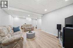 Spacious room featuring light wood-finish flooring, recessed lighting, and a white drop ceiling - 