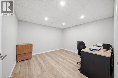 Neutral-toned room featuring wood-finish flooring, white baseboards, and a white acoustical tile ceiling with recessed lighting - 200 Morrison Drive, Caledonia, ON - Indoor Photo Showing Office