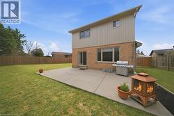 Expansive rear patio featuring a concrete surface, brick lower exterior, and board-and-batten upper exterior - 