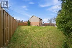 Spacious backyard featuring a manicured lawn, full privacy fencing, and mature perimeter evergreen landscaping - 