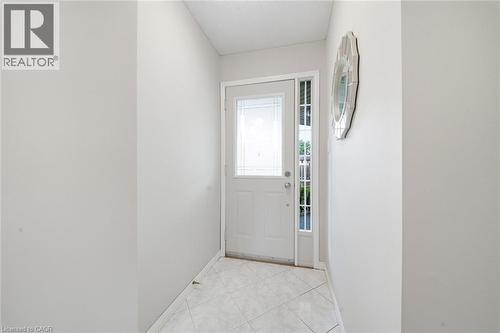 Entryway featuring a white door with decorative glass inserts, a full-length sidelight, and square tile flooring - 200 Morrison Drive, Caledonia, ON - Indoor Photo Showing Other Room