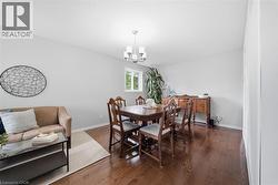 Bright interior room featuring wood-finish flooring, light grey wall paint, and a window providing natural light - 