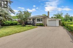 Bungalow exterior with a single-car garage and asphalt driveway - 