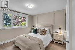 Primary Bedroom featuring a large casement window, crown molding, and engineered hardwood flooring - 