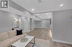 Spacious recreation room featuring recessed lighting, light wood-finish flooring, and a built-in illuminated display niche - 