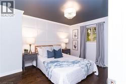 Rich wood-finish flooring complements the detailed white wainscoting - 