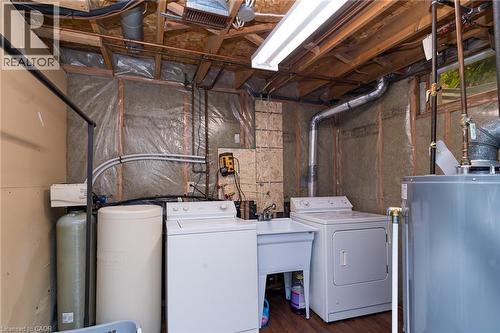 Utility room featuring a laundry sink, exposed wood ceiling joists, and a water heater - 543 Drummerhill Crescent, Waterloo, ON - Indoor Photo Showing Laundry Room