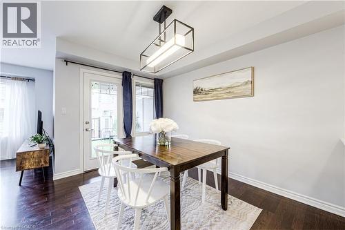 Dining area featuring wood-finish flooring and a contemporary linear chandelier - 1000 Asleton Boulevard Unit# 58, Milton, ON - Indoor Photo Showing Dining Room