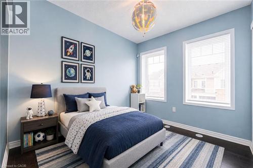 Bedroom featuring light blue walls and dark wood-finish flooring - 1000 Asleton Boulevard Unit# 58, Milton, ON - Indoor Photo Showing Bedroom